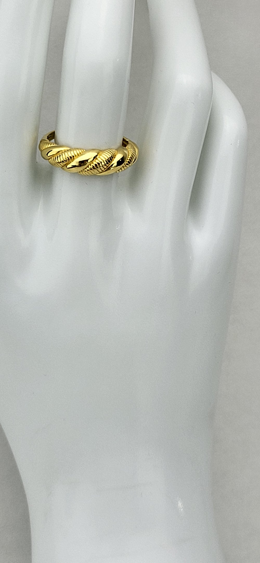 Experience the opulence of our exquisite 14 karat gold plated sterling silver ring. Its polished and textured twist design exudes an air of modern sophistication. Tapering from 6.5mm-2mm, this luxurious piece is available in whole sizes 6-9. Meticulously crafted from .925 sterling silver, it is a truly indulgent addition to any discerning collection.