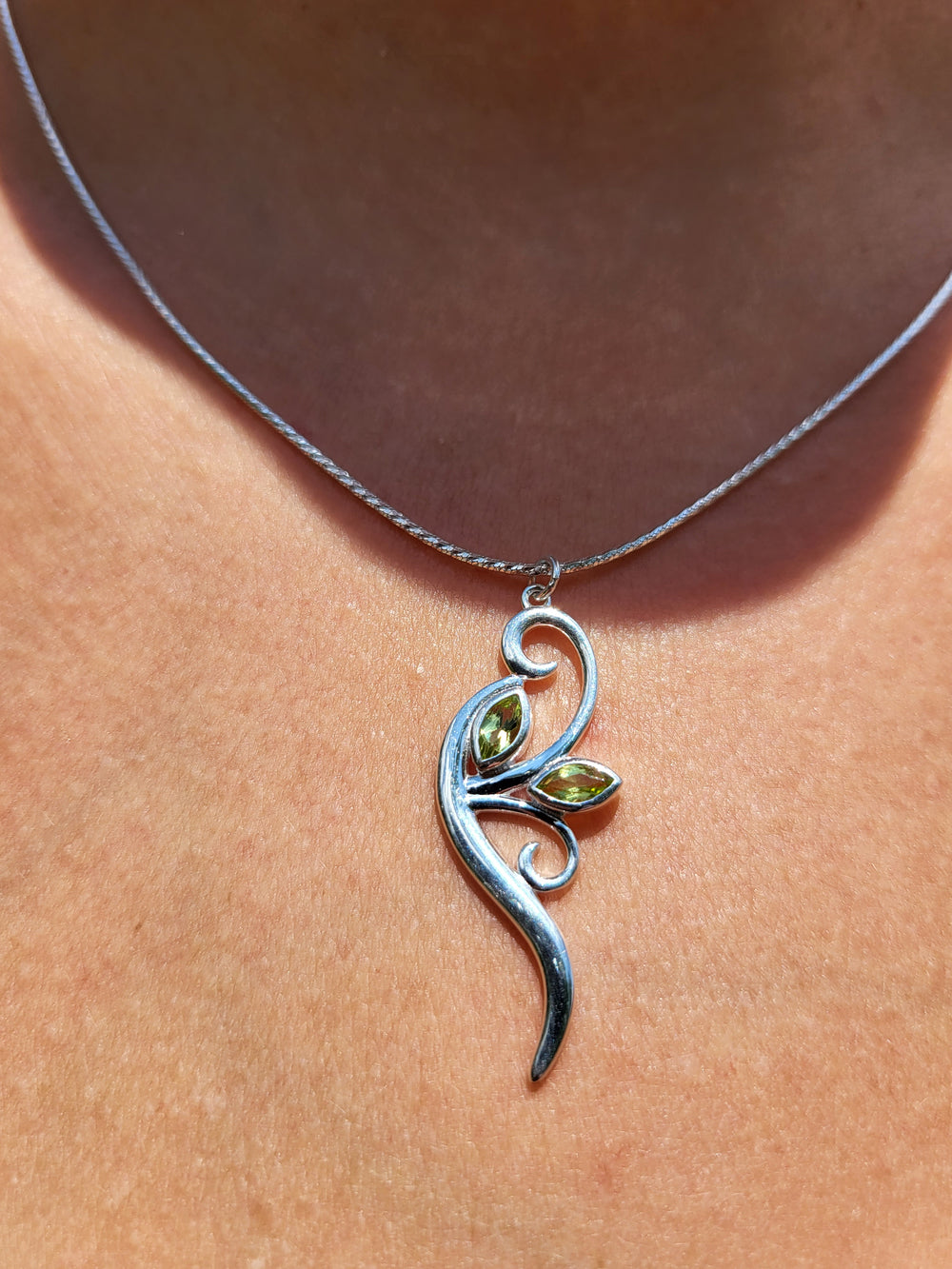 Peridot pendant on a sterling silver box chain.