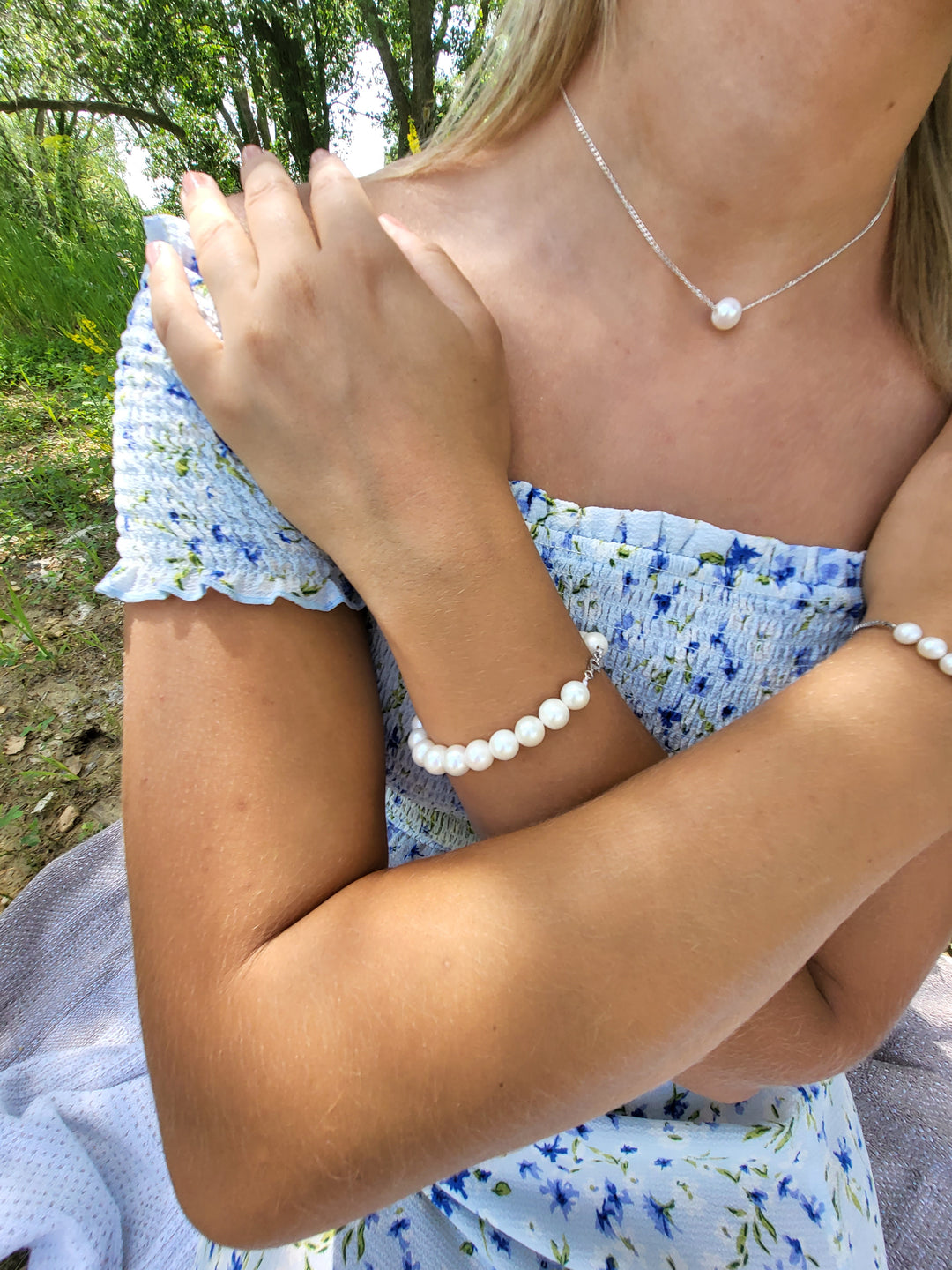 Young woman displaying the pearl beaded bracelet.