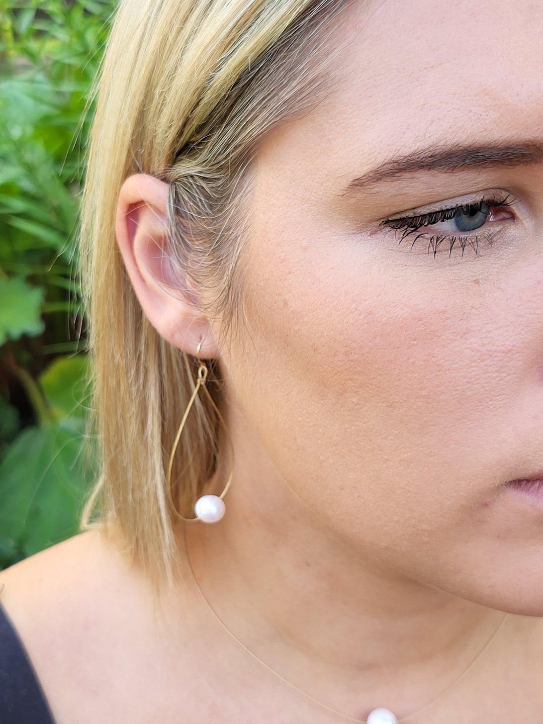 Young woman wearing the wire pearl earrings