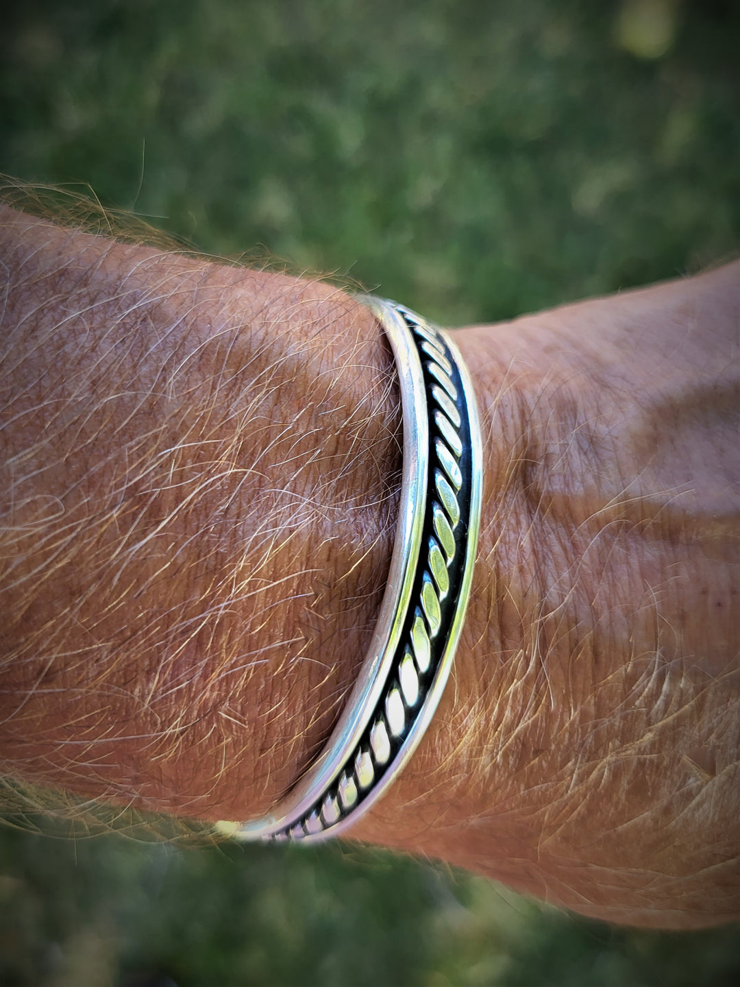 Indulge in the ultimate luxury with our Stud Muffin cuff bracelet. Handcrafted from the finest .925 sterling silver, its intricate rope design is a true masterpiece. Measuring a generous 62mm x 47mm wide, this opulent piece exudes sophistication. The alluring oxidized finish adds depth and character, while the polished silver radiates with a dazzling shine. Elevate your style with our exclusive collection of men's oxidized sterling silver jewelry.