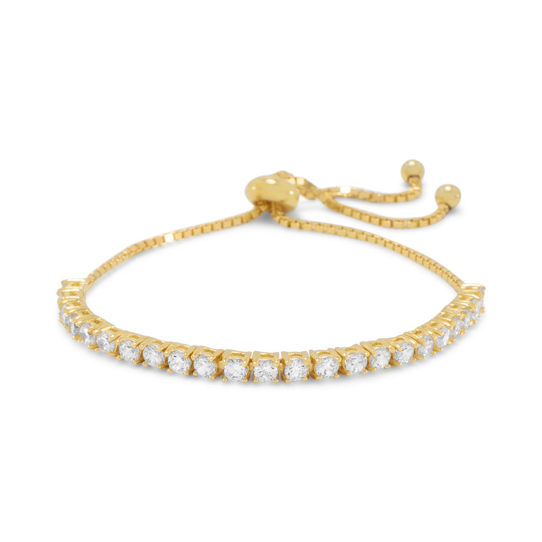 Indulge in the opulence of tennis with our exquisite 14 karat gold plated sterling silver box chain bracelet. Adorned with 3mm cubic zirconias, it adjusts to 9" with a gold plated stopper bead. A perfect gift for your beloved, it pairs seamlessly with our other cubic zirconia and gold jewelry pieces. The value and beauty of the gold plated box chain and .925 sterling silver are unmatched, making this bracelet a true luxury statement piece.