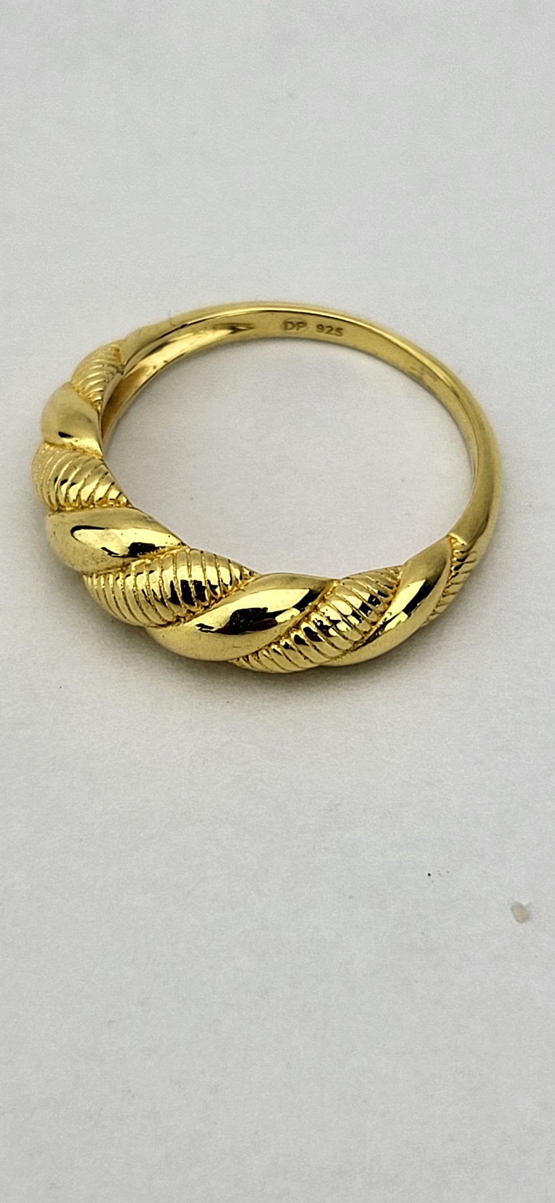 Introducing our bold and stylish 14 karat gold plated sterling silver ring! With its classic look and modern twist design, this ring is a must-have. Available in whole sizes 6-9, it tapers from 6.5mm-2mm. Crafted from .925 sterling silver, it boasts a polished and textured finish. Elevate your style with this stunning piece!