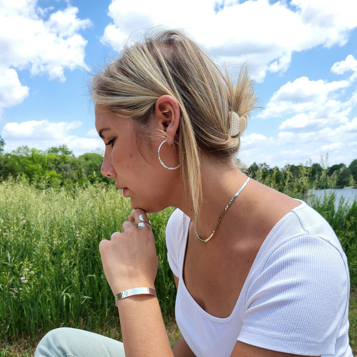 Image of woman wearing our hammered sterling silver jewelry pieces.