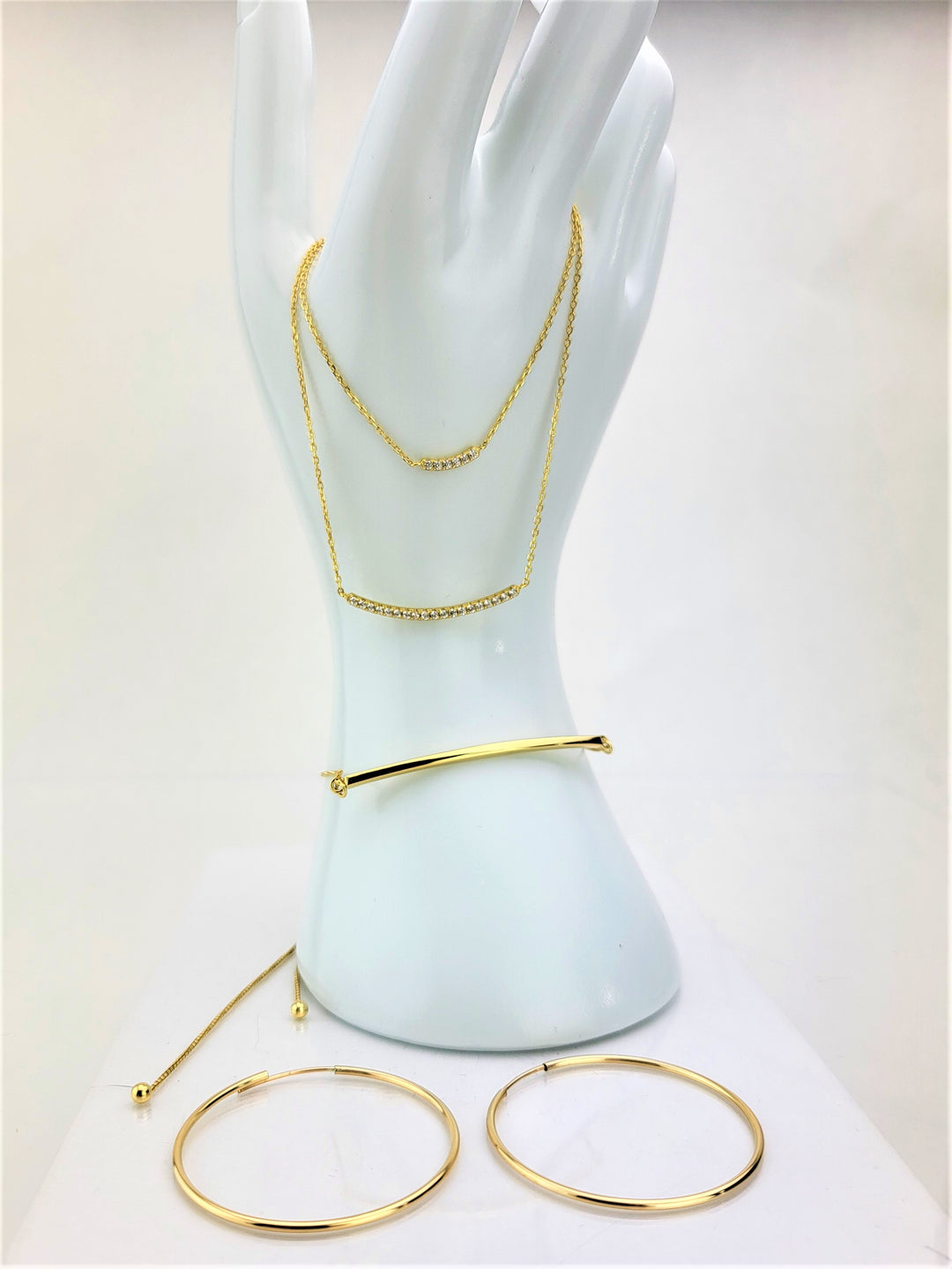 Image of gold jewelry ensemble that include the gold bar bolo bracelet.