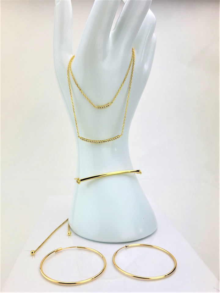 Introducing our showstopper: the double strand necklace that will make jaws drop! Meticulously crafted in 14 karat gold, it boasts curved cubic zirconia bars that exude pure elegance. With a secure lobster clasp closure, this accessory is a must-have for every occasion. Pair this beautiful double strand necklace with our other gold bar jewelry!