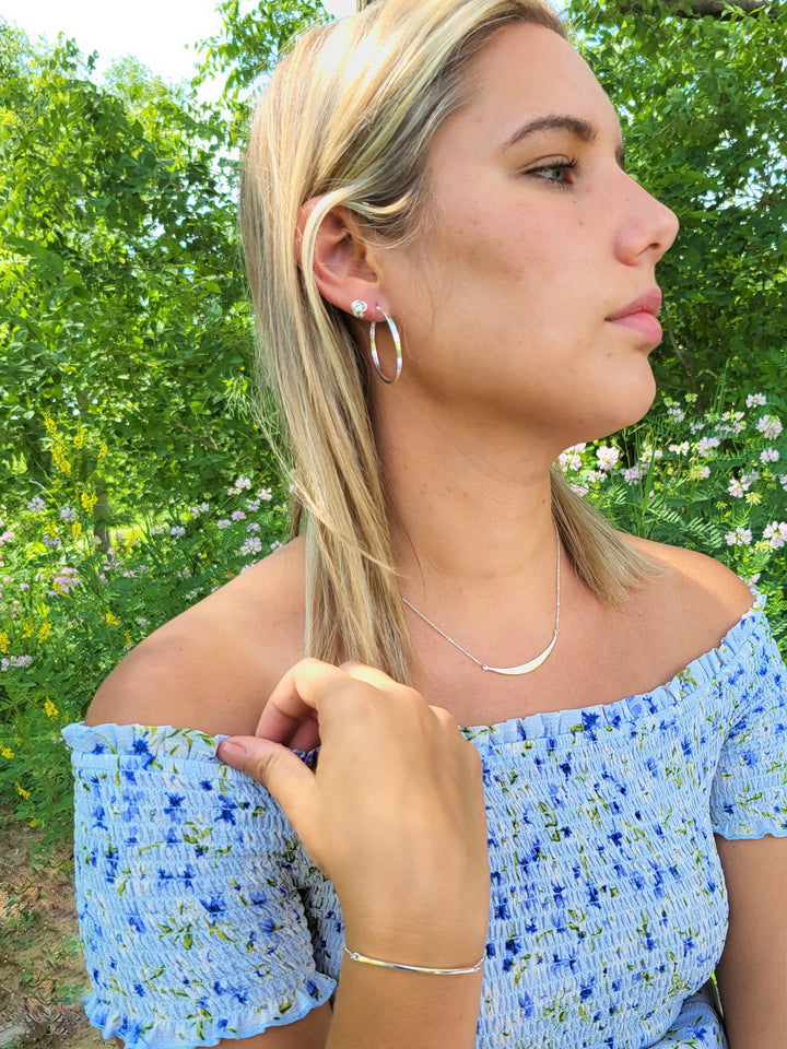 Outdoor image of woman wearing a sterling silver jewelry ensemble.