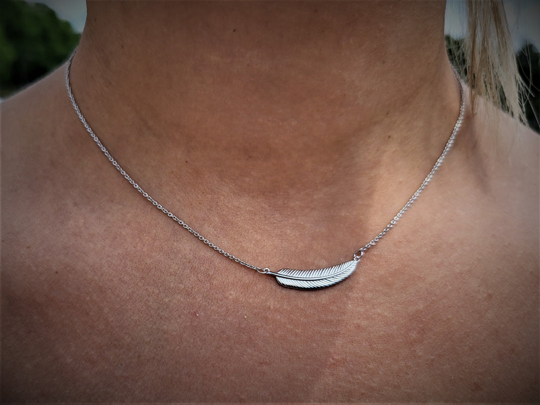 Fly high with our rhodium plated feather necklace, symbolizing freedom and grace. Perfectly paired with our feather collection.