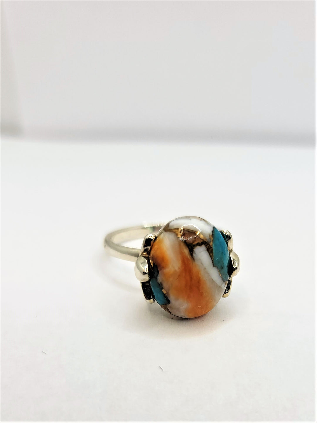 Introducing the epitome of luxury jewelry design - our Simply Unique ring. This exquisite piece is a true testament to the artistry and refinement of fine jewelry, crafted from the finest .925 sterling silver and adorned with a compressed spiny oyster and turquoise stone.