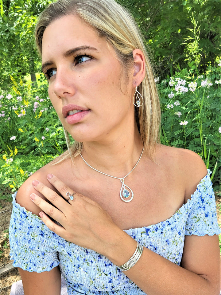 Enhance your fashion game with our luxurious 3mm omega necklace, meticulously handcrafted in Italy from premium Sterling Silver. Model is wearing the 16 " 3 mm domed omega necklace w the topaz pear drop slide. 