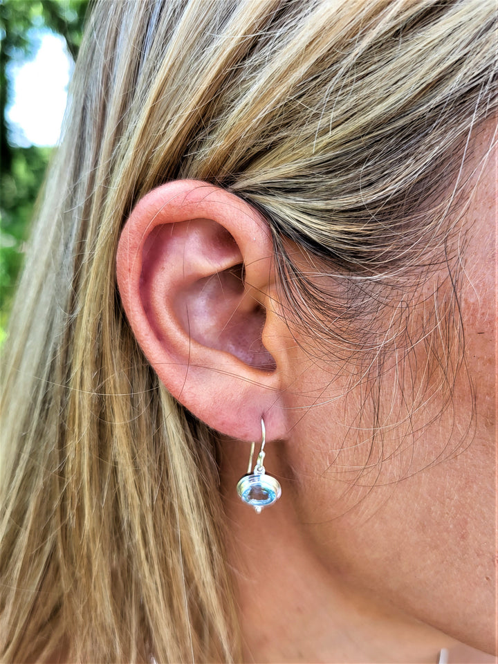 Elevate your style with our stunning sterling silver earrings, featuring a captivating blue topaz drop.