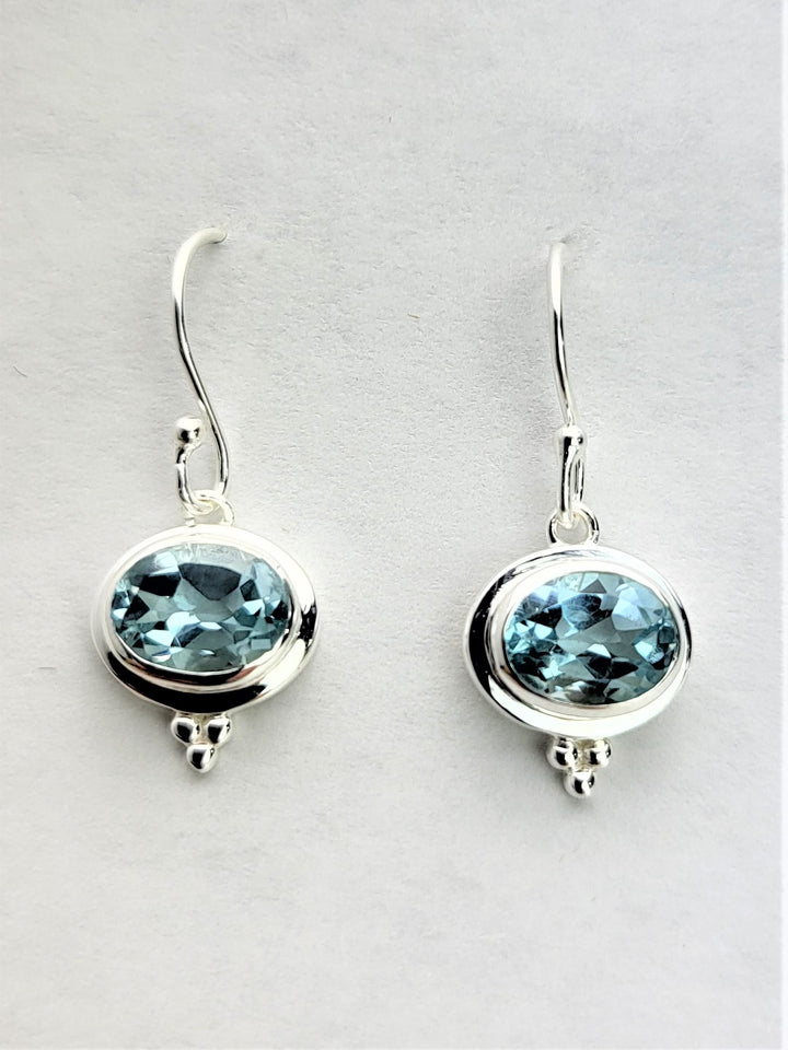 Enhance your elegance with our exquisite sterling silver earrings, showcasing a mesmerizing blue topaz pendant.