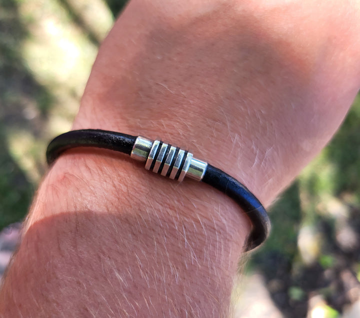 Man wearing the black leather bracelet.