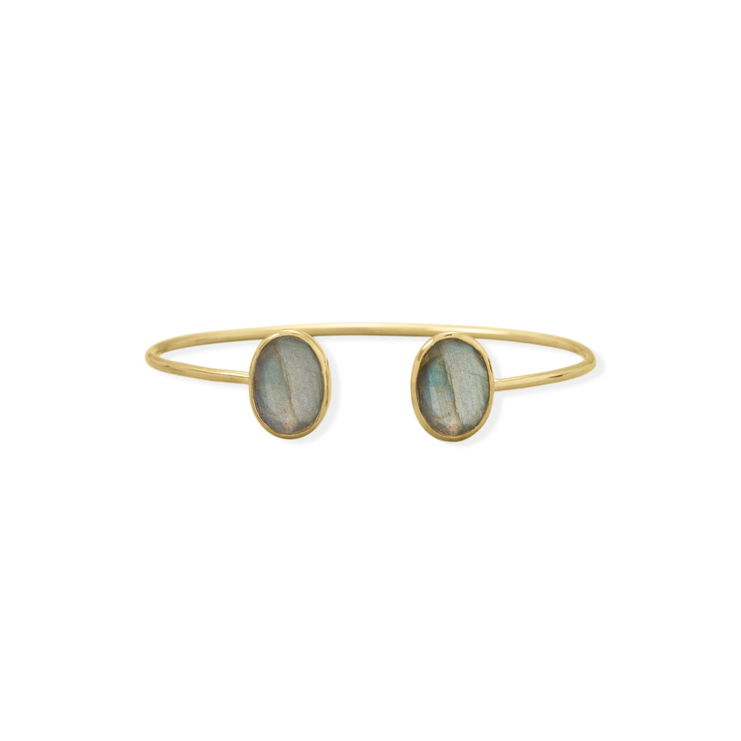 Indulge in the opulence of our 14 karat gold plated sterling silver cuff bracelet, adorned with two exquisite labradorite stones measuring 13mm x 10mm. The earthy hues of the stones are complemented by the cool blues of the cuff tubing, measuring 2mm round. The value of the gold plating and the beauty of the labradorite stones make this piece a true treasure. The adjustable cuff design ensures a perfect fit, while the .925 sterling silver guarantees its quality and longevity.