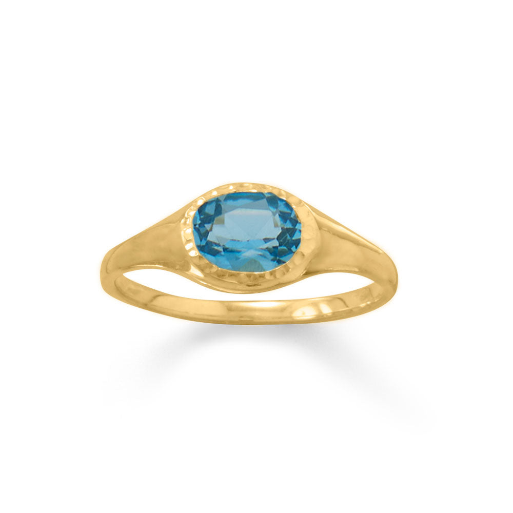 Elevate your style with this exquisite 14 karat gold plated sterling silver ring. Adorned with a mesmerizing 5mm x 7mm oval swiss blue topaz, its textured edge adds a touch of sophistication. With a maximum width of 7mm and a polished band tapering to 1.5mm, this ring exudes elegance. Crafted from .925 sterling silver, it guarantees exceptional quality. Available in whole sizes 5-9.